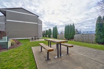 Beautifully landscaped community with a courtyard featuring picnic tables